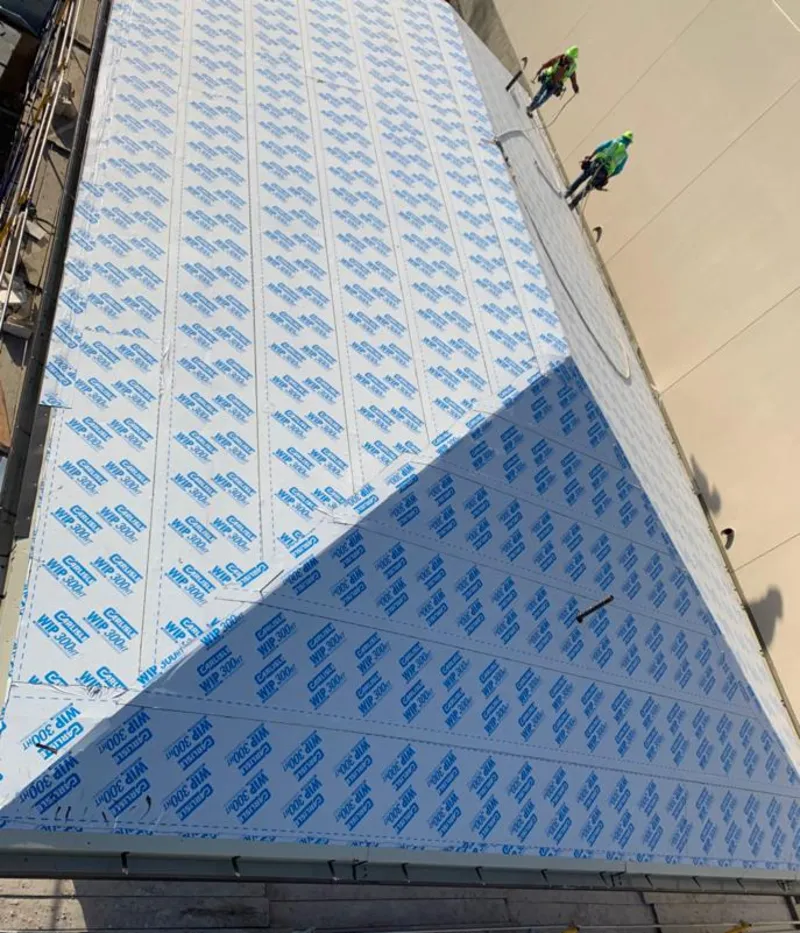 Professional roofers installing underlayment on a metal roof in Huntington Beach